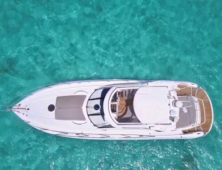 Starboard profile of 50 ft Sunseeker Sea Eagle luxury charter yacht anchored in crystal turquoise Caribbean water near Cancun
