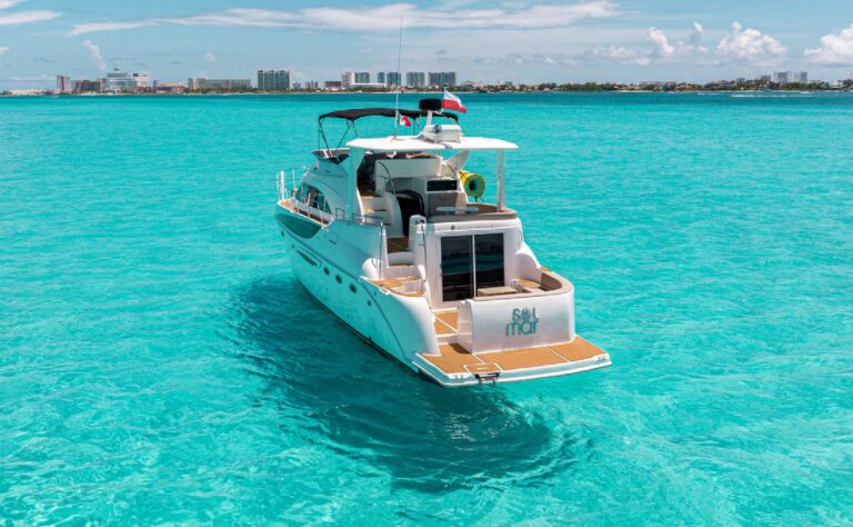 Aft dock view of 50 ft Meridian Sol Mar charter yacht with Garmin helm, diamond-quilted gray seating and teak deck at Cancun marina