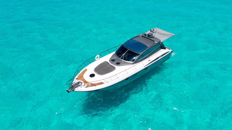 50 ft Cranchi Mediterranean yacht rental speeding through turquoise Caribbean waters at Riviera Maya, aerial view showing full hull, large white wake and sleek sport profile