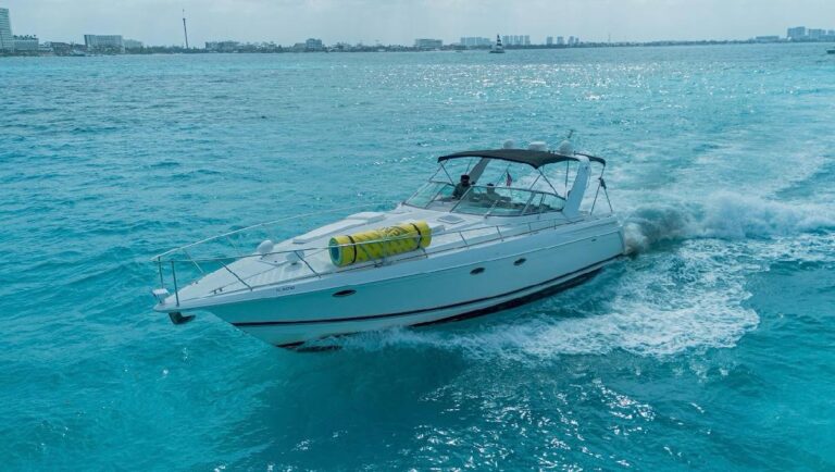 42 ft Formula Mayasea yacht charter racing through turquoise Caribbean water with Cancun Hotel Zone skyline visible in the background