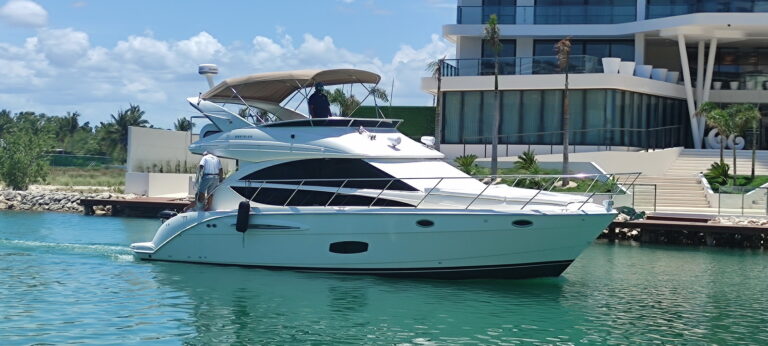 Starboard profile of 43 ft Meridian Endless luxury flybridge yacht docked at Cancun Hotel Zone marina beside modern luxury hotel building