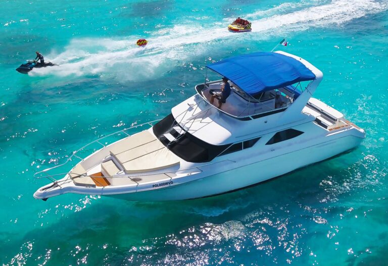 Aerial view of 48 ft Sea Ray Flybridge Jackie luxury yacht charter anchored in turquoise Caribbean water near Cancun with jetski and water toys visible in background