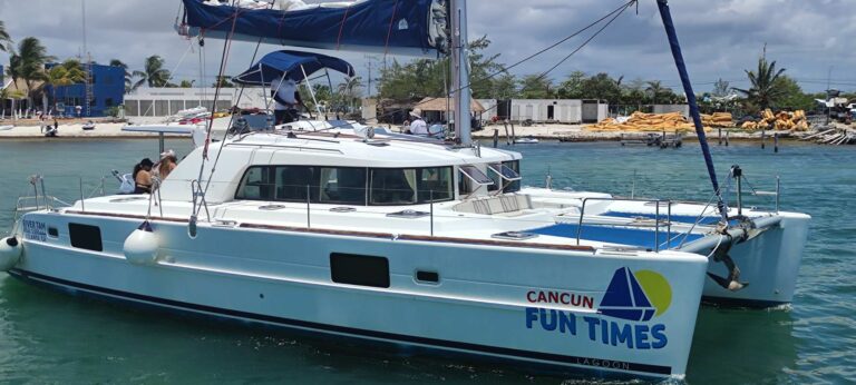 44 ft Lagoon catamaran Fun Times with Cancun Fun Times logo docked beside a marina with sail furled, ready for private group yacht charter in Cancun