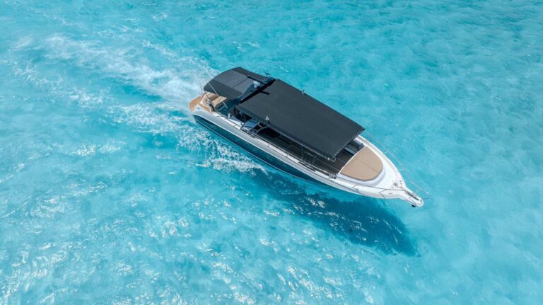 Aerial view of 55 ft Sea Ray Eolo luxury yacht cruising over turquoise Caribbean waters off Cancun, ideal for large group charters and parties.