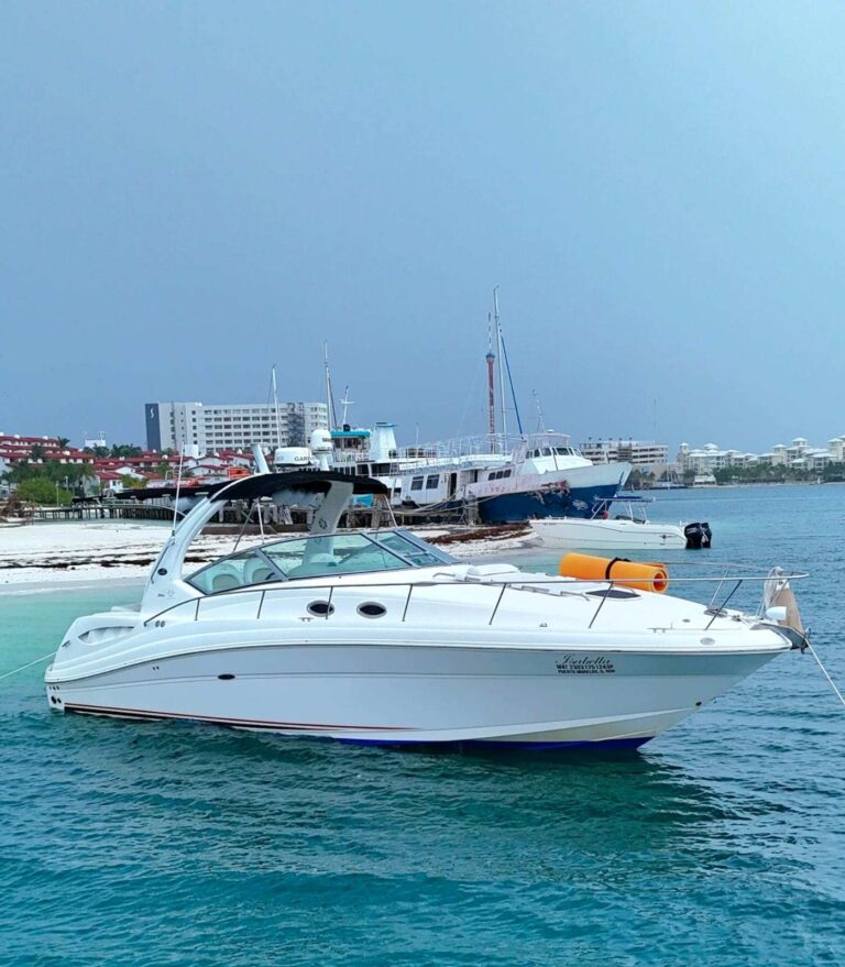 36 ft Sea Ray Isabella luxury boat moored near Cancun marina beach with snorkel float on deck, white hull with blue accent stripe, yacht rental Cancun.