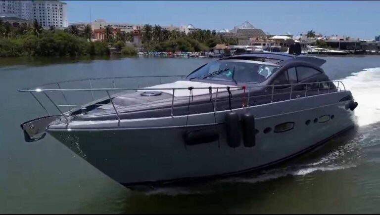 Full galley of 60 ft Pershing Lupo luxury yacht with stainless steel countertops, electric cooktop, stainless sink, microwave, and full bar condiment shelf.
